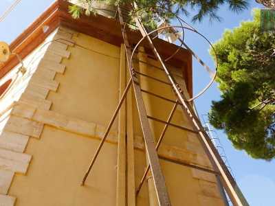 Il silos � poi fiancheggiato da una strettissima scala metallica protetta da cerchi posti a distanze regolari, proprio come un�altra scala che si trova dal lato opposto, nella parte in muratura della torretta